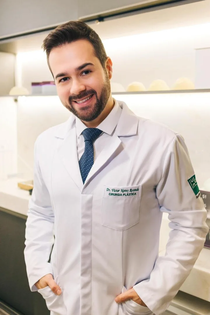 Dr. Victor Rezende, cirurgião plástico, de jaleco em seu consultório